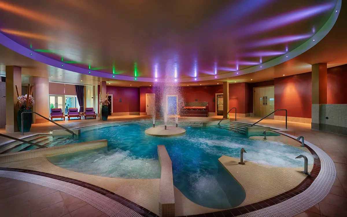 Luxurious indoor spa pool with hydrotherapy jets and colourful mood lighting.